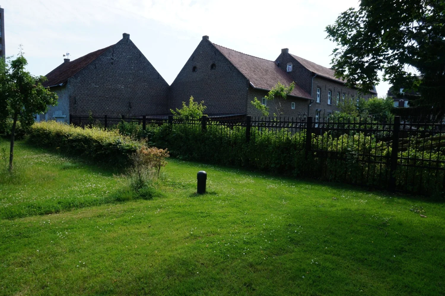 De groene tuin en achterzijde van Stadsboerderij PS40 in Sittard